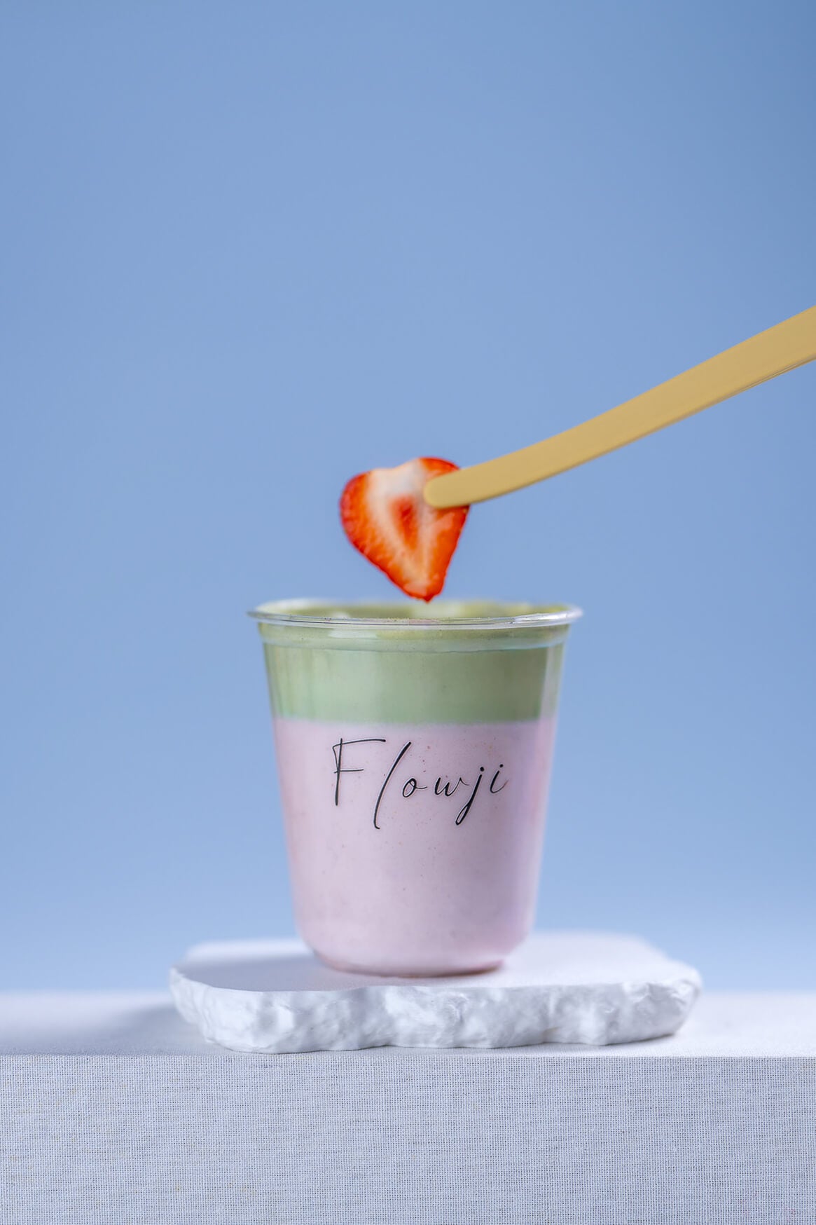 Fresh strawberry garnish being hand-finished on a Flowji signature cloud drink, highlighting handcrafted beverage preparation.