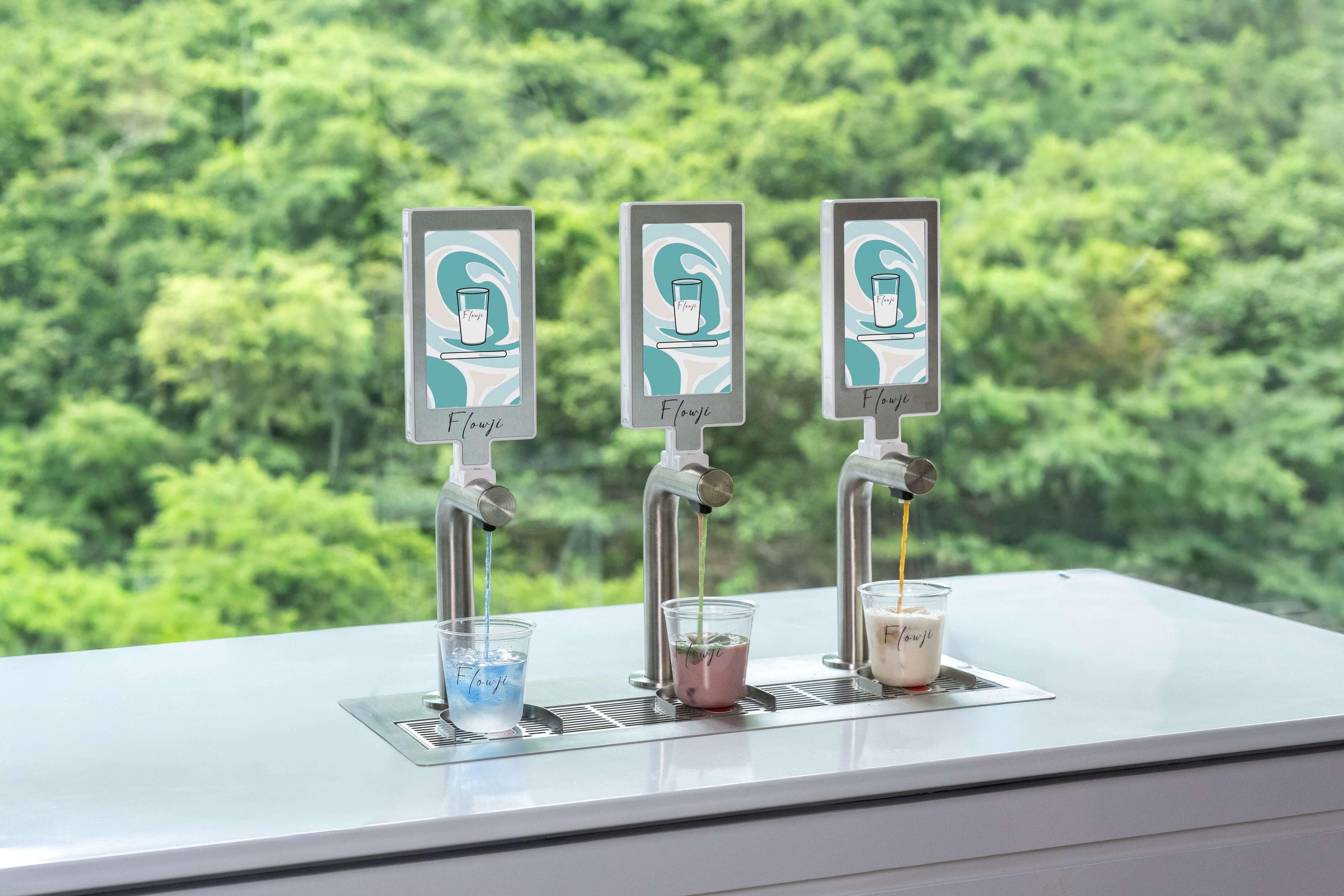 Flowji automated beverage dispensing system with three taps preparing freshly made drinks for events and corporate catering.